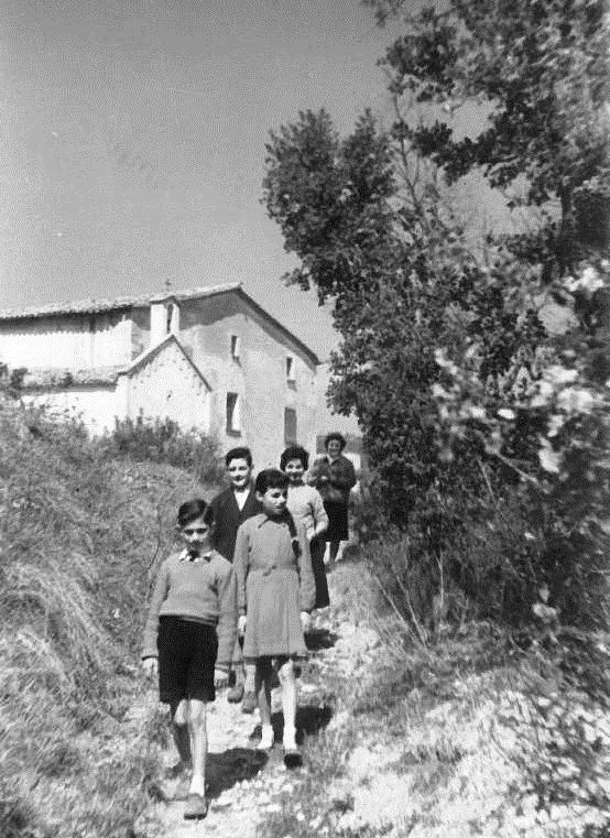 1960 El Joan de cal Valls i l'Aurora de cal Valls amb el Josep de cal Llorenç i la Glòria de cal Llorenç baixant de l'Ermita de Sant Miquel.jpg