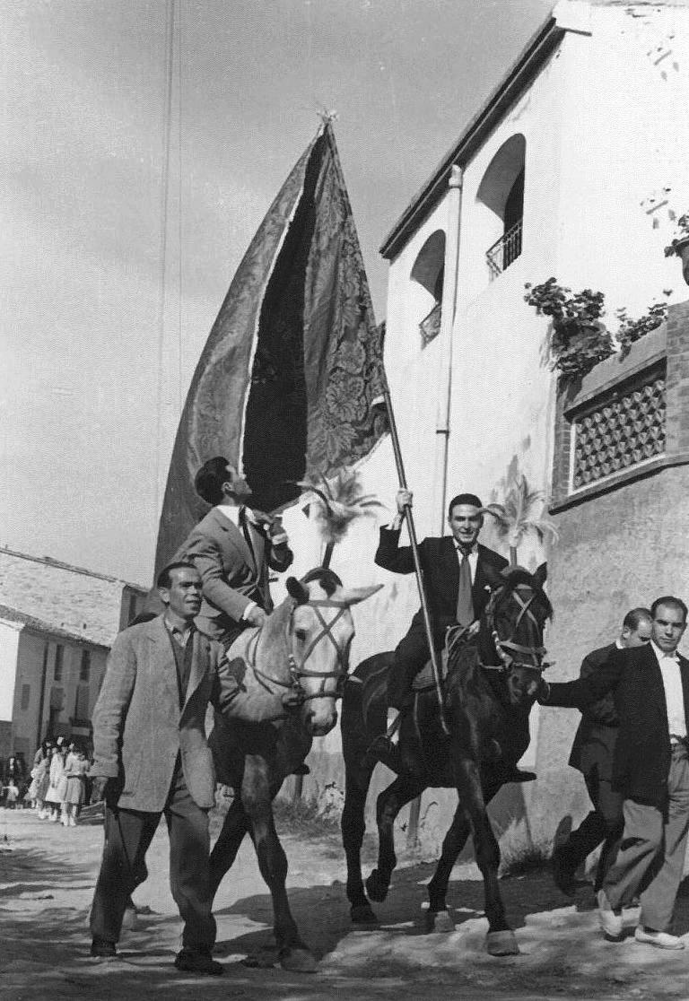 INAUGURACIÓ ESGLÈSIA PALLER PROVISIONAL 1957. Quimet de ca la Florinda i Josep de cal Sopes portant l'estandard amb l'Àngel mosso de cal Daniel i el Lluís de cal Batistó.jpg